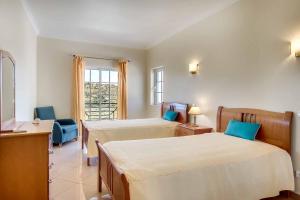 ein Hotelzimmer mit zwei Betten und einem Fenster in der Unterkunft Villa Sunny in Albufeira + 26 Fotos