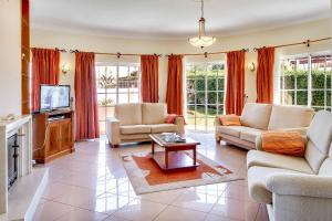 ein Wohnzimmer mit zwei Sofas und einem Fernseher in der Unterkunft Villa Sunny in Albufeira