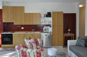 a kitchen with two chairs and a living room at El Ladinia Someda in Moena
