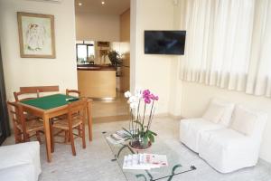 een woonkamer met een tafel en een witte bank bij Hotel Caribe in Viareggio