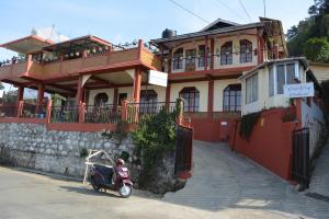 uno scooter parcheggiato di fronte a un edificio di Dew Drop In a Shillong
