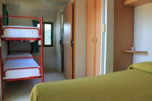 a room with two bunk beds and a hallway at Camping Fontana delle Rose in Mattinata