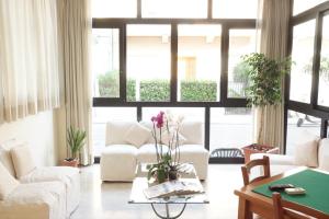 een woonkamer met witte meubels en een groot raam bij Hotel Caribe in Viareggio
