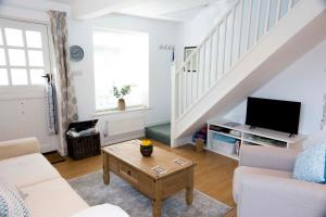 a living room with a couch and a tv at Pixie Cottage in Eastbourne