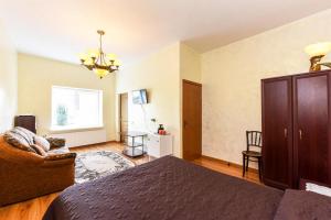 een slaapkamer met een bed, een bank en een stoel bij Astra-Poilsis Sventojoje in Šventoji