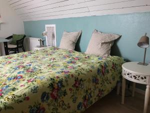 a bedroom with a bed with a floral bedspread at Præstøgaard in Præstø