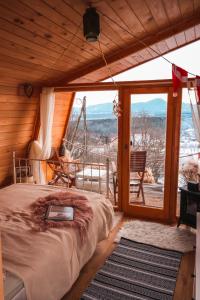 a bedroom with a bed and a large window at Panorama Glamping Visole in Slovenska Bistrica