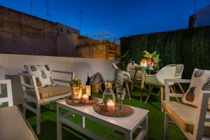 a patio with chairs and a table with candles at Genteel Home Galera in Seville