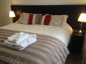 a bed with white towels sitting on top of it at Cloverlea Cottages in Bristol