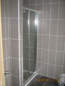 um chuveiro com uma porta de vidro na casa de banho em 24 Fairfield Road em Uttoxeter