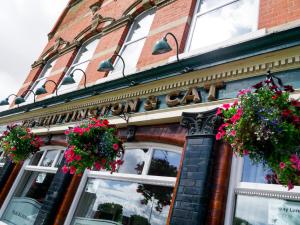 a building with flower baskets on the front of it at The Whittington and Cat in Hull