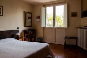 a bedroom with a bed and a large window at La Vecchia Cantina in Stradella