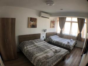 um quarto com 2 camas e uma janela em Samuil Apartments em Burgas
