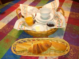 a table with two baskets of bread and two glasses of orange juice at Boizen in Saint-Jean-de-Boiseau