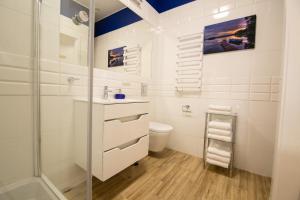 a white bathroom with a shower and a toilet at Very Berry - Podgorna 1c - Old City Apartments, check in 24h in Poznań