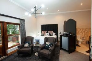 Un dormitorio con una cama y dos sillas. en IL Castello, en Clarens