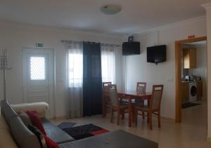 ein Wohnzimmer mit einem Esstisch und Stühlen in der Unterkunft Saudade Peniche Apartment in Peniche
