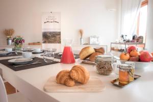 a kitchen counter with croissants and bread on it at Oasi Picolit in Povoletto +21 photos