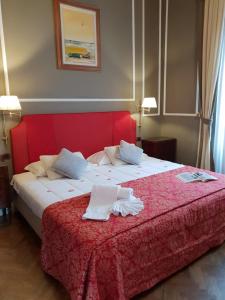 um quarto com uma cama grande e uma cabeceira vermelha em Il Marzocco Boutique B&B em Florença