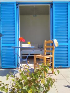 a table and a chair sitting in front of a door at Enalion House in Agios Ioannis Kaspaka