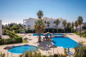 a view of a resort with two pools and palm trees at B33 - Praia do Vau Apartment in Portimão