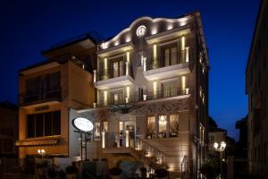 a building with a clock on the side of it at Princier Fine Resort & SPA in Rimini