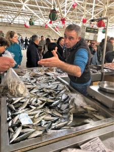 a man standing in front of a table of fish at Central Tavira apartment, Casa Oliverio in Tavira