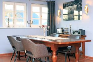 a dining room with a wooden table and chairs at Ferienwohnung im Blauen Haus in Ahrenshoop
