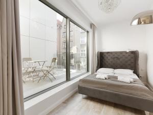 1 dormitorio con cama y ventana grande en Lavoo Boutique Apartments, en Gdansk