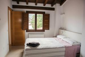 a bedroom with a bed and a window at Ca' la Paz - Mogarraz in Mogarraz