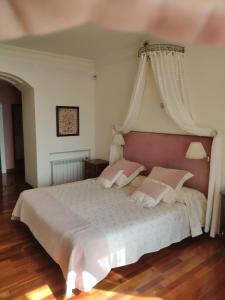 a bedroom with a white bed with a canopy at Villa Antumalal B&B in Málaga