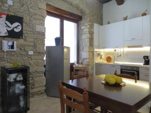 een keuken met een tafel en een koelkast bij La Pietra Antica in Paola
