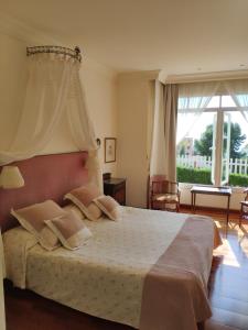 a bedroom with a large bed and a large window at Villa Antumalal B&B in Málaga