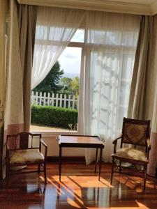 a room with two chairs and a table and a window at Villa Antumalal B&B in Málaga
