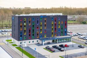 a building with colorful windows and a parking lot at ibis budget Rotterdam The Hague Airport in Rotterdam