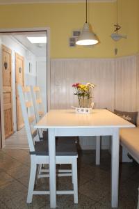 a white table with chairs and a vase of flowers on it at InselGlück in Fehmarn