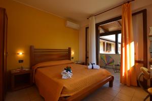 una camera d'albergo con un letto fiorito di Hotel Iride by Marino Tourist a San Vito lo Capo
