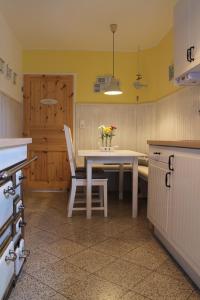 a kitchen with a table with a vase of flowers on it at InselGlück in Fehmarn