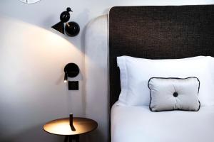 a bedroom with a bed with a white pillow and a table at Hôtel Eiffel Saint Charles in Paris