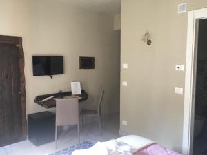 a bedroom with a desk and a tv on the wall at Casa D'amore in Riomaggiore