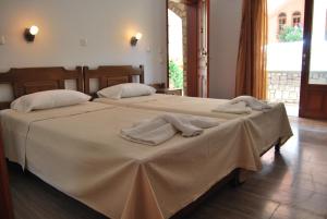 Dos camas en una habitación con toallas. en Vasiliki Apartments, en Plataniás