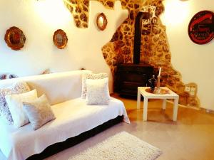 sypialnia z białym łóżkiem i piecem opalanym drewnem w obiekcie Ethno Village Kokorici w mieście Vrgorac