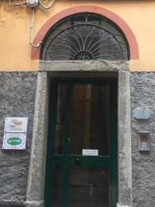 a green door on a building with a sign above it at Casa D'amore in Riomaggiore