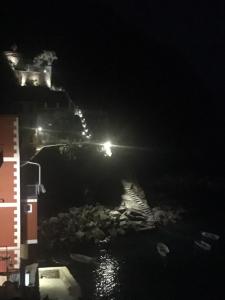 a nightime view of the ocean with a lighthouse at Casa D'amore in Riomaggiore