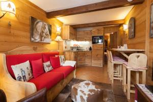 een woonkamer met een rode bank en een keuken bij L'Atelier du Temps - CHARME in Courmayeur in Courmayeur