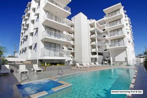 ein Gebäude mit einem Swimmingpool vor einem Gebäude in der Unterkunft Ocean Views Resort Caloundra in Caloundra