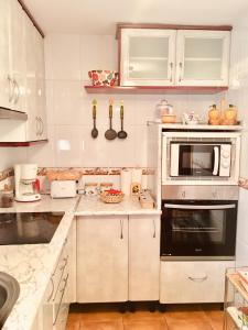 a kitchen with a stove and a microwave at Chalet El Descanso in Rades de Abajo