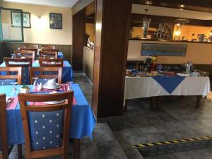 Hotel Brisamar في Bañugues: غرفة طعام مع طاولات وكراسي زرقاء