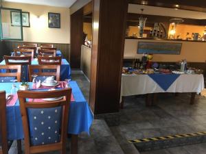 un comedor con mesas y sillas azules en Hotel Brisamar, en Bañugues