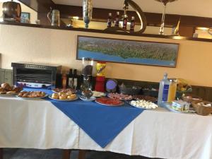 uma mesa com pratos de comida em Hotel Brisamar em Bañugues